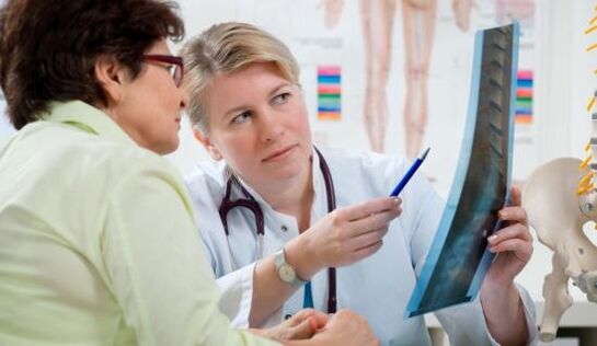um médico examina um raio-x para dor nas costas